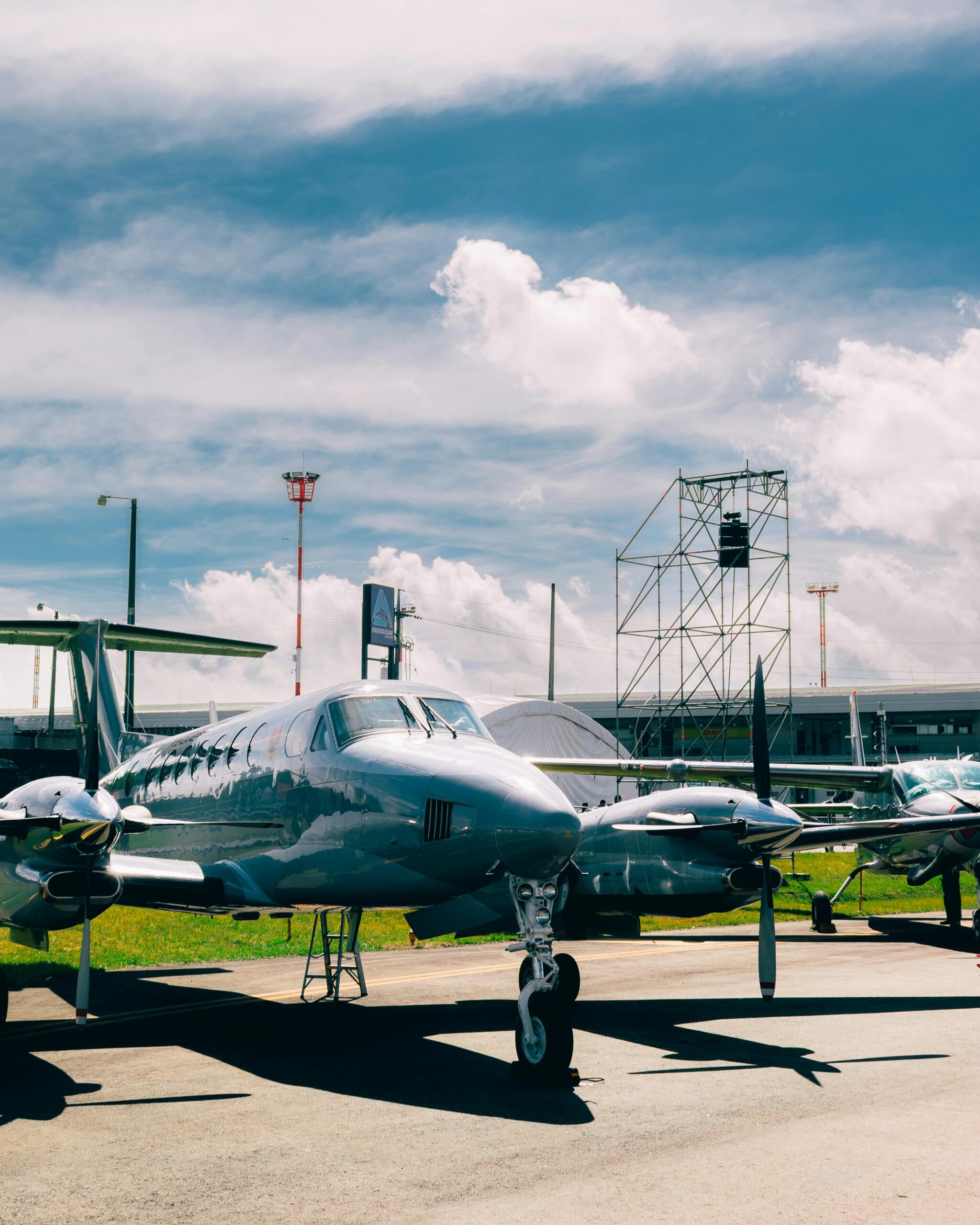 Small propeller planes on a grass airstrip under a clear blue sky, ideal for aviation themes.